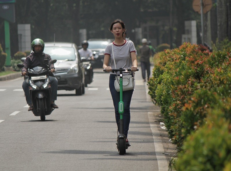 Ilustrasi warga menaiki skuter listrik atau otopet Grab Wheels melintas di jalan raya kawasan Senayan, Jakarta, Rabu (13/11). MI/Adi Maulana Ibrahim.