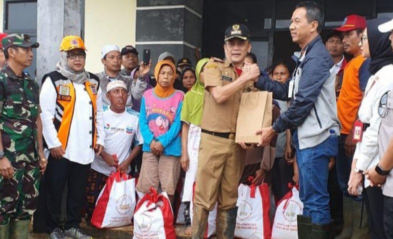 Kepala Sekretariat Kepresidenan, Heru Budi Hartono (kanan) menyerahkan bantuan dari Presiden Jokowi di Kecamatan Sukajaya, Kabupaten Bogor, Minggu (5/1/2020). ANTARA/Humas Pemkab Bogor