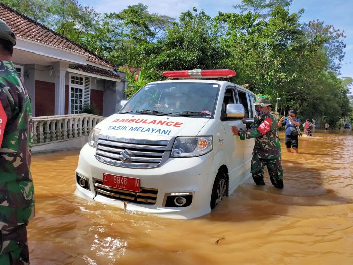 Anggota TNI mendorong ambulans puskesmas yang mogok karena terjebak banjir di Kecamatan Sukaresik, Kabupaten Tasikmalaya, Kamis (25/3/2021). (Foto: MI/Kristiadi)