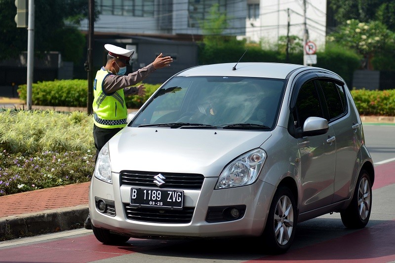 Ilustrasi--Petugas menghalau kendaraan dengan plat nomor ganjil yang menuju kawasan Jalan Sudirman di Jakarta. (MI/Susanto)