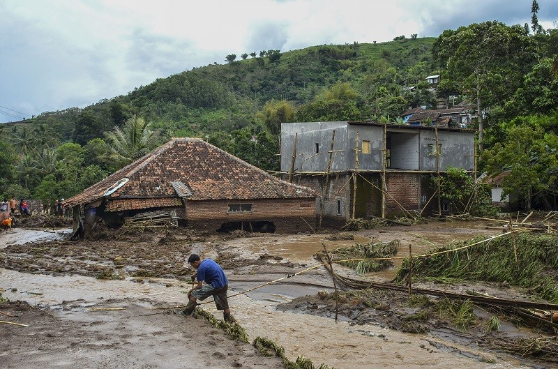 Seorang warga memperbaiki pipa saluran air untuk pertanian usai diterjang banjir bandang di Kampung Cileles, Desa Cintamanik, Kecamatan Karang Tengah, Kabupaten Garut, Jawa Barat. (Foto: ANTARA/Adeng Bustomi)