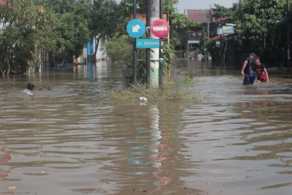 Sejumlah anak bermain di tengah banjir yang terjadi di Perumahan Pondok Hijau Permai. Antonio/Medcom.id