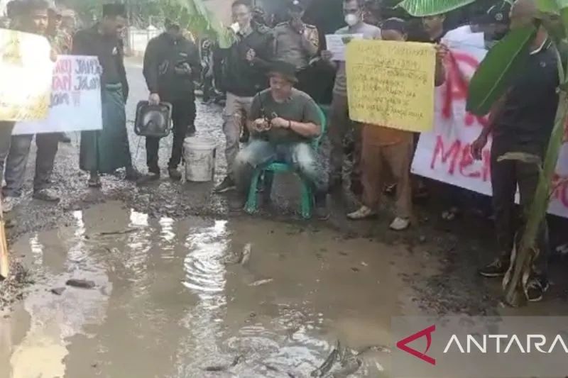 Warga menggelar aksi protes memancing ikan di jalan Letnan Sukarna, Ciampea, Kabupaten Bogor, Jawa Barat. Foto: Antara/M Fikri Setiawan