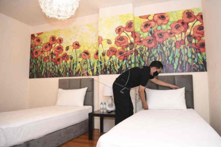 Seorang karyawan merapikan tempat tidur di kamar hotel. Foto: Antara/M Risyal Hidayat/foc.