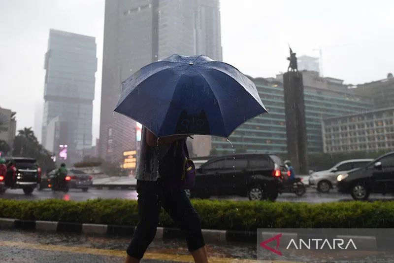 Warga berjalan sambil membawa payung saat hujan di kawasan Bundaran Hotel Indonesia, Jakarta. Foto: Antara/Akbar Nugroho Gumay/wsj/pri