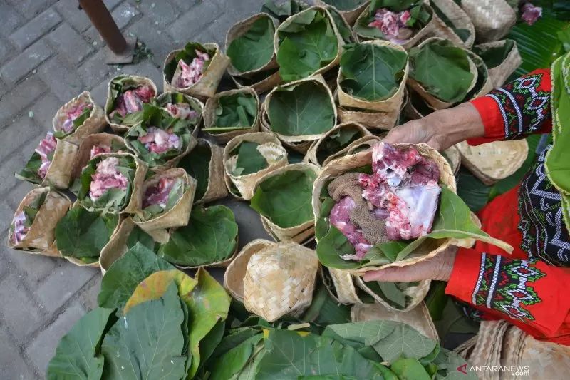 Arsip Foto. Warga mewadahi daging kurban menggunakan besek beralas daun untuk mengurangi sampah plastik pada Hari Raya Idul Adha. (ANTARA FOTO/SYAIFUL ARIF)