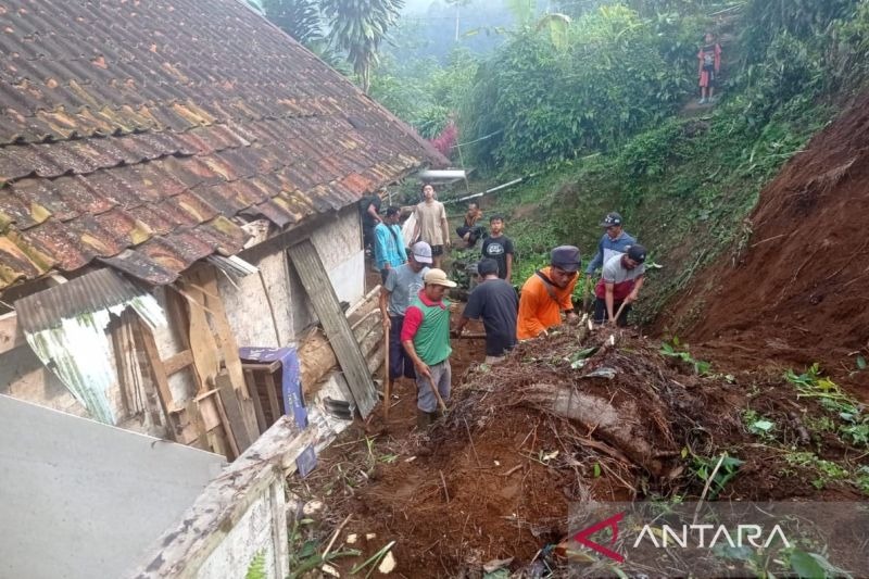 Warga Desa Cibokor, Kecamatan Cibeber, Cianjur, Jawa Barat, dibantu relawan dan petugas membersihkan longsoran yang menutup pekarangan rumah warga, Rabu (7/9/2022).(ANTARA/Ahmad Fikri)