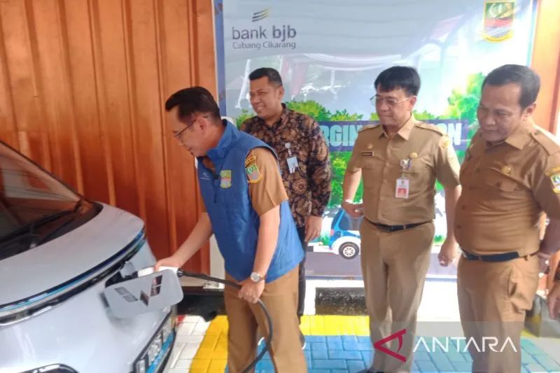 Penjabat Bupati Bekasi Dani Ramdan mengisi daya kendaraan listrik saat peluncuran stasiun pengisian bahan bakar listrik di halaman Bank Jabar Banten Cabang Pemkab Bekasi, Senin (24/10/2022). ANTARA/Pradita Kurniawan Syah.