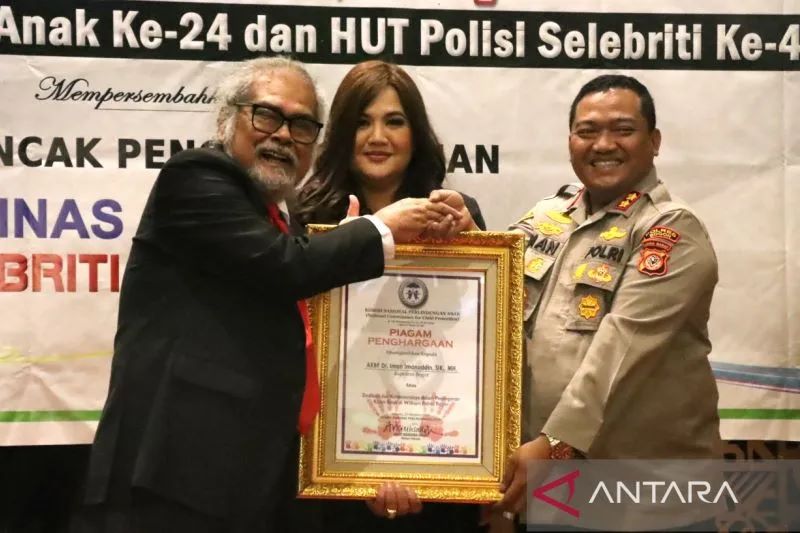 Ketua Komnas A Arist Merdeka Sirait (kiri) memberikan penghargaan kepada Kapolres Bogor AKBP Iman pada acara peringatan HUT ke-24 Komnas Perlindungan Anak di Jakarta Selatan, Senin (24/10/2022). (ANTARA/HO-Humas Polres Bogor)