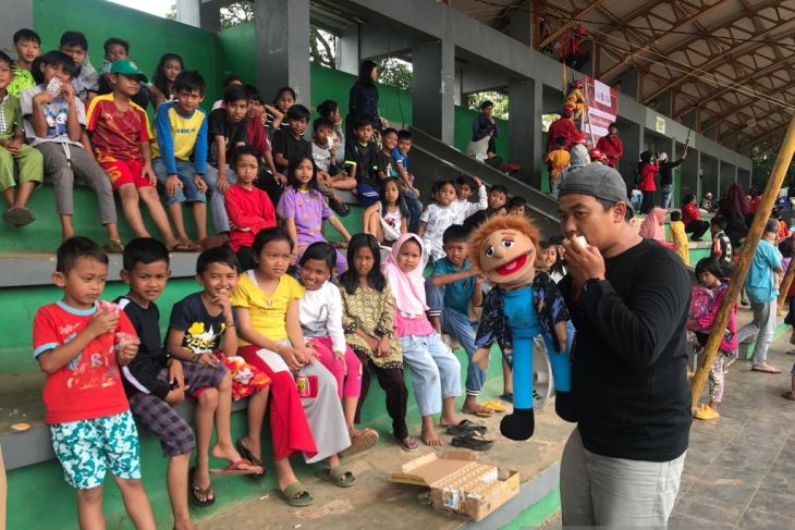 Anak-anak korban gempa yang mengungsi mendengarkan cerita dari pendongeng di kompleks Taman Prawatasari, Kabupaten Cianjur, Provinsi Jawa Barat, Minggu (27/11/2022). (ANTARA/Devi Nindy)