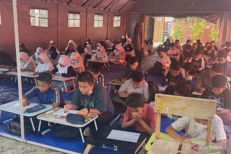 Siswa SDN Ibu Jenab I Cianjur, Jawa Barat, sudah mulai menjalani proses belajar mengajar normal sejak Senin (13/12/2022) di dalam tenda karena ruang kelas mereka rusak akibat gempa.(ANTARA/Ahmad Fikri).