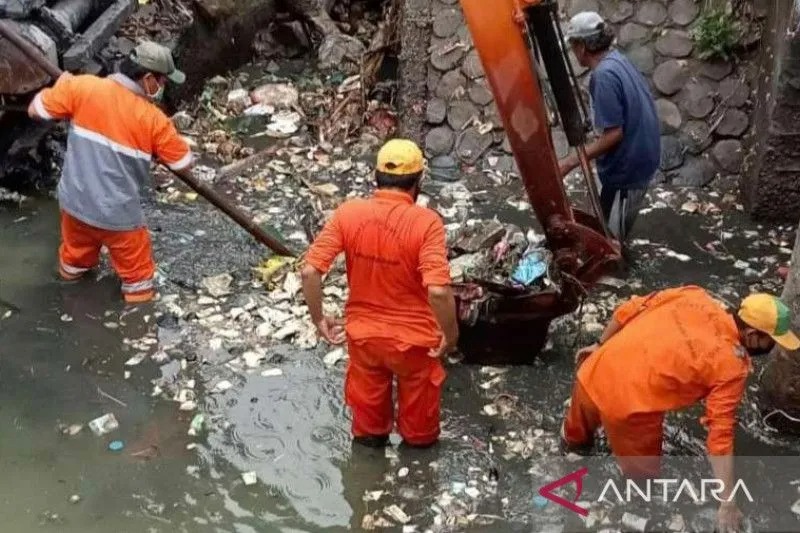 Petugas Dinas Lingkungan Hidup Kabupaten Bekasi, Jawa Barat membersihkan sampah di aliran Sungai Cikarang Hilir, Desa Sukaringin, Kecamatan Sukawangi, Senin (16/1/2023). (FOTO ANTARA/Pradita Kurniawan Syah).