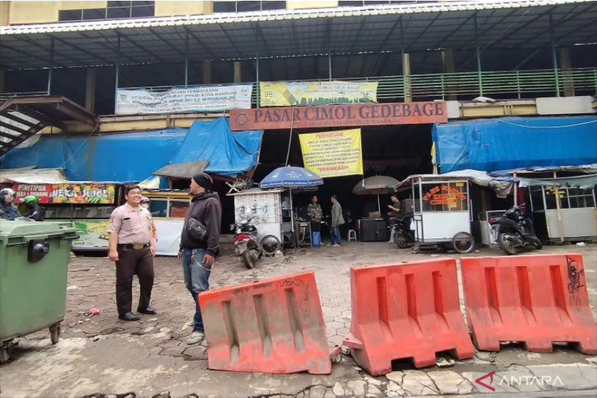 Petugas keamanan melakukan sosialisasi penutupan pasar di Pasar Cimol Gedebage, Kota Bandung, Jawa Barat, Rabu (22/3/2023). Foto:ANTARA/Bagus Ahmad Rizaldi