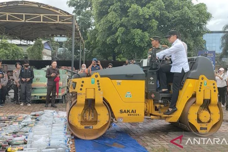 Wali Kota Bogor, Jawa Barat Bima Arya Sugiarto (kemeja putih) bersama Kapolresta Bogor Kota Kombes Pol Bismo Teguh Prakoso (mengendarai alat berat) dan Dandim 0606 Letkol Inf Ali Ikhwan (seragam TNI) saat memusnahkan miras dan petasan selama Bulan Ramadan