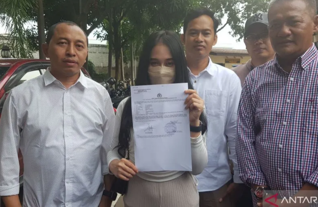 Korban kasus dugaan pelecehan seksual karyawati perusahaan AD (24) menunjukkan bukti laporan di Mapolres Metro Bekasi pada Sabtu (6/5/2023). (ANTARA/Pradita Kurniawan Syah).