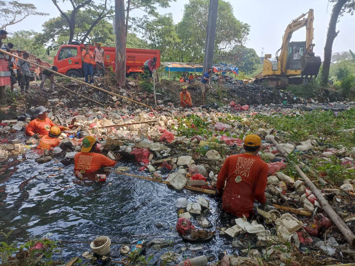 Petugas DLH Kabupaten Bekasi membersihkan sampah yang memenuhi saluran irigasi Perumahan Bumi Anggrek, Desa Karangsatria, Kabupaten Bekasi, Jawa Barat. Sumber: Pemprov Jabar