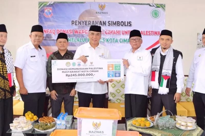 Penjabat Wali Kota Cimahi Dicky Saromi (tengah) menyerahkan secara simbolis donasi masyarakat setempat yang digalang Baznas di Cimahi, Jawa Barat, Kamis (23/11/2023). (ANTARA/HO-Pemkot Cimahi)
