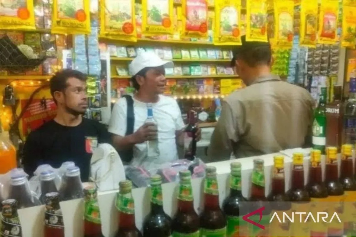 Petugas berpakaian preman menyita minuman keras hasil operasi di sebuah warung yang berlokasi di Kampung Kandang, Desa Jayamukti, Kecamatan Cikarang Pusat, Senin. (ANTARA/Pradita Kurniawan Syah)
