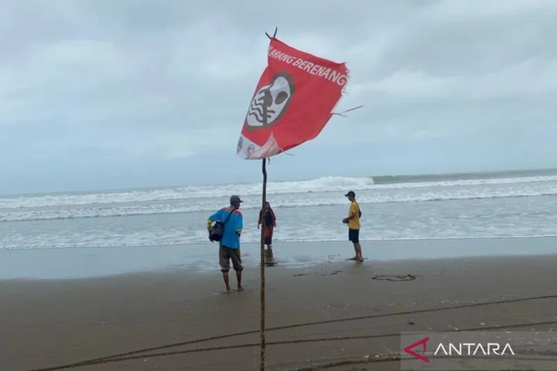 Sejumlah pengunjung bermain di kawasan pantai yang terdapat bendera peringatan larangan berenang di Pantai Pangandaran, Jawa Barat beberapa waktu lalu. (ANTARA/Feri Purnama)