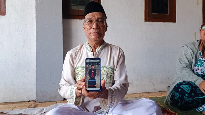 Dasuki (61) saat memperlihatkan foto anaknya yang menjadi korban kecelakaan di Tol Jakarta - Cikampek.