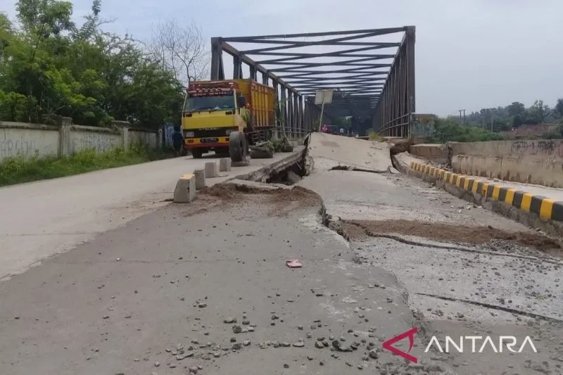 Jalan longsor area Jembatan Cipamingkis di Kecamatan Cibarusah, Kabupaten Bekasi, Jawa Barat pada Minggu (10/3/2019). Area ini kerap longsor hingga kini akibat konstruksi dinding penahan sungai tidak mampu melawan deras arus air saat debit tinggi. (ANTARA